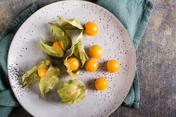Ripe fruit physalis on a plate. Organic vegetarian food. Top view. Closeup