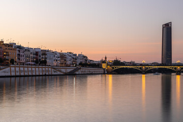 Sunset over the authentic neighborhood of Tirana in Seville with views on Calle Betis, Torre Sevilla and with awesome reflections in the river Guadalquivir, creating magic atmosphere and views