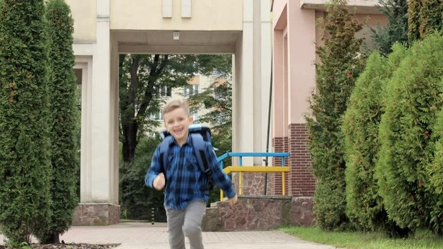 Little boy with backpack runing to home with school. First grader.