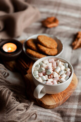 Fototapeta na wymiar warm cozy bedroom winter or autumn concept, cup of hot chocolate on tray, candles throw