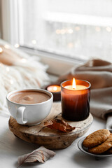 Obraz na płótnie Canvas warm cozy window arrangement, winter or autumn concept, coffe, candles throw lights