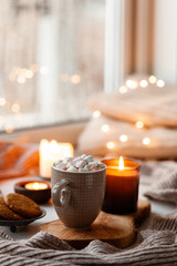 warm cozy window arrangement, winter or autumn concept, coffe, candles throw lights