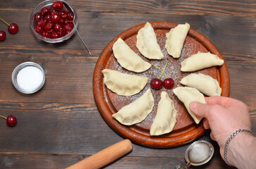 traditional ukrainian food dumplings with cherries and a mans hand