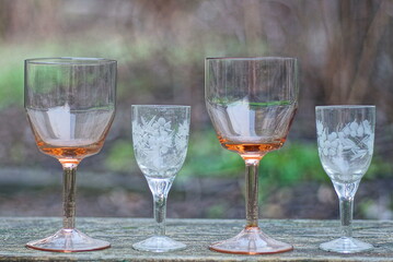 a row of white and brown glass crystal goblets on a gray wooden table 