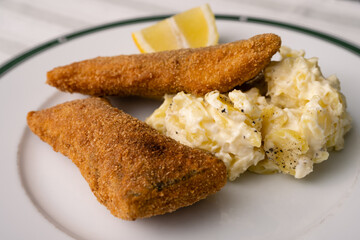 Breaded and Fried Carp Fillet with Mayonnaise Potatoe Salad and Lemon, a Traditional Christmas Dish in Bohemia and Austria