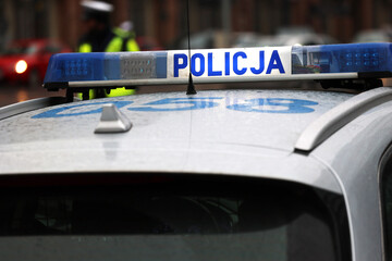 Incydent policji w mieście. - Sygnalizator błyskowy niebieski na dachu radiowozu policji polskiej drogowej. - obrazy, fototapety, plakaty