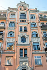 Fototapeta premium part of a brown white stone wall of an old historical building with windows on a city street