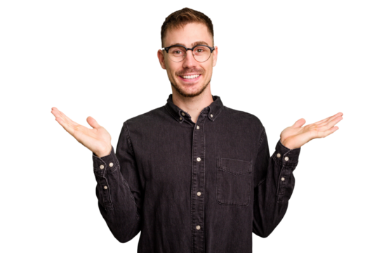 Young caucasian man cut out isolated makes scale with arms, feels happy and confident.