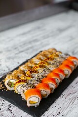 Assorted japanese sushi rolls on black background.