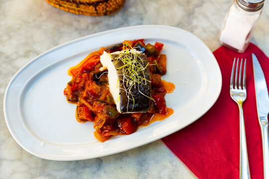 Popular dish of Spanish cuisine is Bacala, made from fish with vegetables and decorated with greenery on top