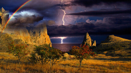 Thunderstorm and rainbow over the Black Sea, Crimea. Lightning flashes and a rainbow shines over...