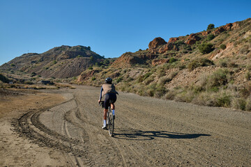 Fit male cyclist riding dirt trails on gravel bike.
Man riding gravel bike on gravel road in scenic...