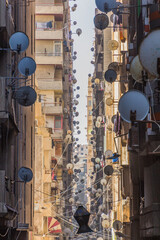 Narrow alley with satellite dishes in Alexandria, Egypt