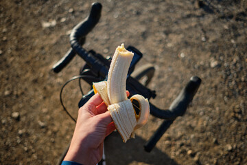 Banana on bicycle background.
Cyclist eating banana.
Healthy nutrition of a cyclist.
Healthy snack...
