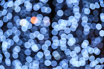 Abstract bright background, bokeh of burning blue light bulbs.