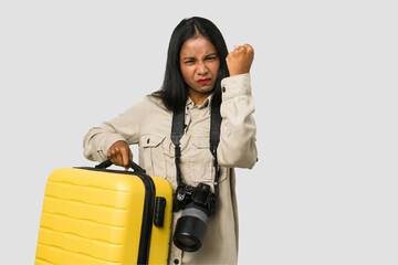 Young photographer Indian woman holding a suitcase cut out isolated showing a mobile phone call gesture with fingers. - obrazy, fototapety, plakaty