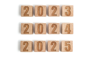 Wooden cubes with numbers 2023, 2024 and 2025, white background.