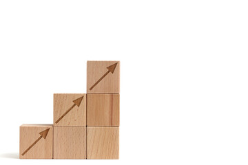 Wooden cubes are built form stair and arrows rising top.Concept growth and development.