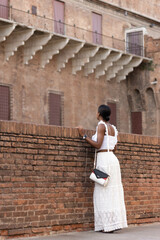 Portrait of turist woman dressed in white getting to know Europe, Ferrara. Italy