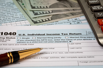 1040 individual income tax return forms, cash money and calculator. Federal tax return, income tax...