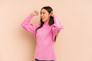 Young colombian woman isolated on beige background raising fist after a victory, winner concept.