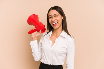 Young business colombian woman shouting with a megaphone isolated