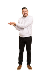 Full body adult latin man cut out isolated holding a copy space on a palm.