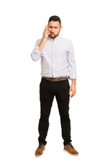 Full body adult latin man cut out isolated with fingers on lips keeping a secret.