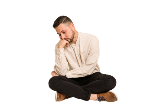 Adult latin man sitting on the floor cut out isolated who feels sad and pensive, looking at copy space.