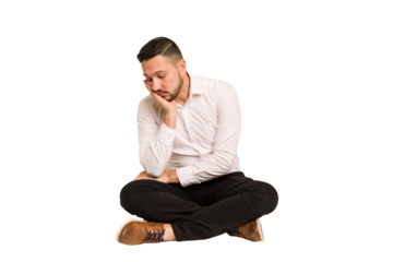 Adult latin man sitting on the floor cut out isolated who is bored, fatigued and need a relax day.