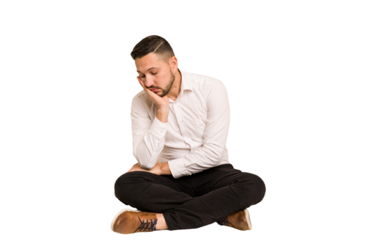 Adult latin man sitting on the floor cut out isolated who is bored, fatigued and need a relax day.