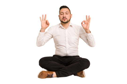 Adult latin man sitting on the floor cut out isolated relaxes after hard working day, she is performing yoga.