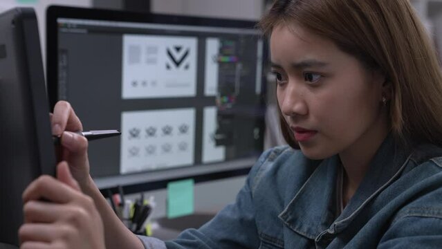 Asian female graphic designer working on computer drawing sketches logo design. The concept of a new brand. Professional creative occupation with idea.