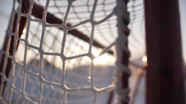 A close-up shot of a hockey goal on a winter background on the street.