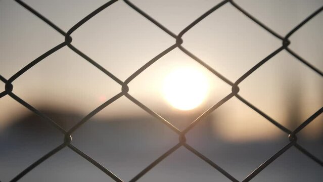 Metallic wire fence with hoarfrost on barren cold winter landscape - camera slowly slide