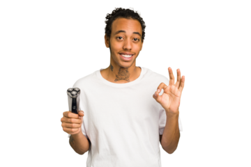 Young African American man holding a razor isolated cheerful and confident showing ok gesture.