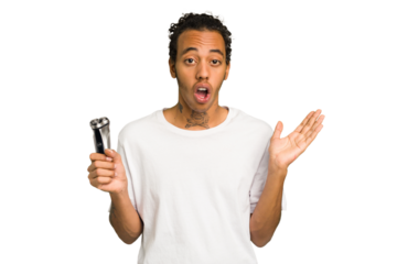Young African American man holding a razor isolated surprised and shocked.