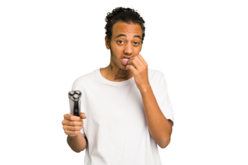 Young African American man holding a razor isolated biting fingernails, nervous and very anxious.