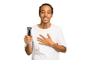 Young African American man holding a razor isolated laughs out loudly keeping hand on chest.