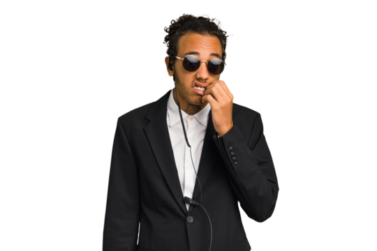 Young African American bodyguard man isolated biting fingernails, nervous and very anxious.