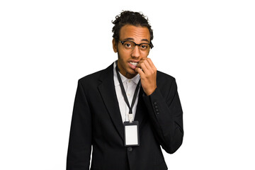 Fototapeta premium Young African American business man with badge isolated biting fingernails, nervous and very anxious.