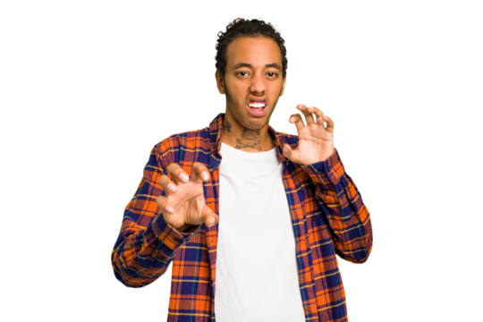 Young African American man isolated showing claws imitating a cat, aggressive gesture.