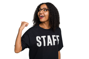 Young african american staff woman isolated points with thumb finger away, laughing and carefree.