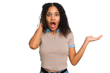 Young african american woman with curly hair cut out isolated impressed holding copy space on palm.