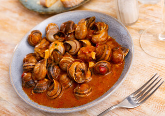 Andalusian style appetizer of land snails caracoles stewed with salsa of tomatoes, garlic,...
