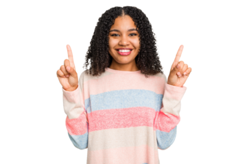 Young african american woman with curly hair cut out isolated indicates with both fore fingers up showing a blank space.