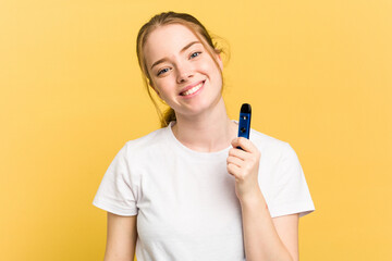Young cute woman holding a vaper isolated on yellow background happy, smiling and cheerful.