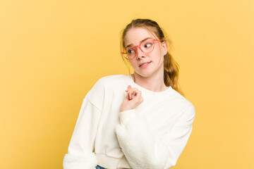 Young caucasian redhead woman isolated on yellow background confused, feels doubtful and unsure.