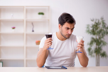 Young male student testing soft drink