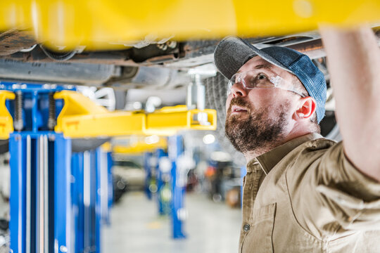 Professional Mechanic Inspecting Car Undercarriage